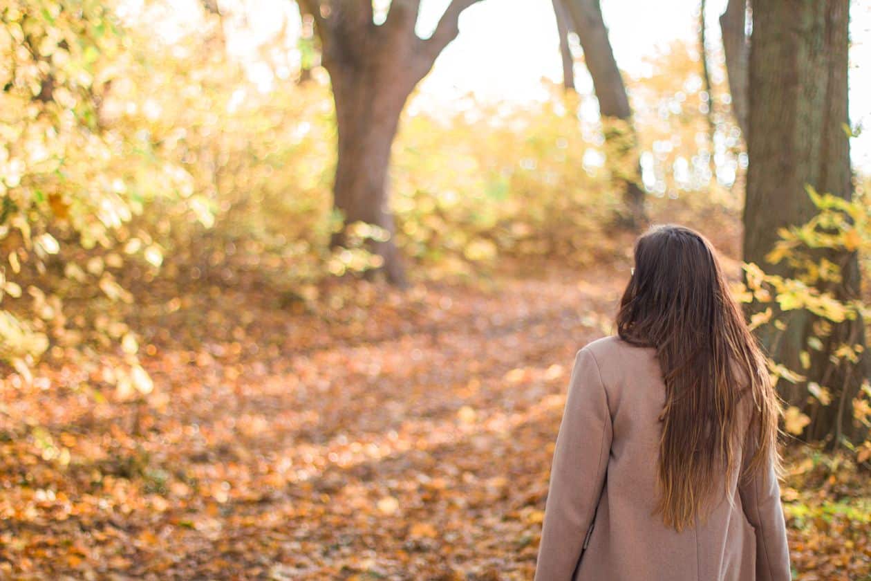 Kvinde på gåtur i skoven illustrerer nervesystemets betydning ved fibromyalgi og arvelighed