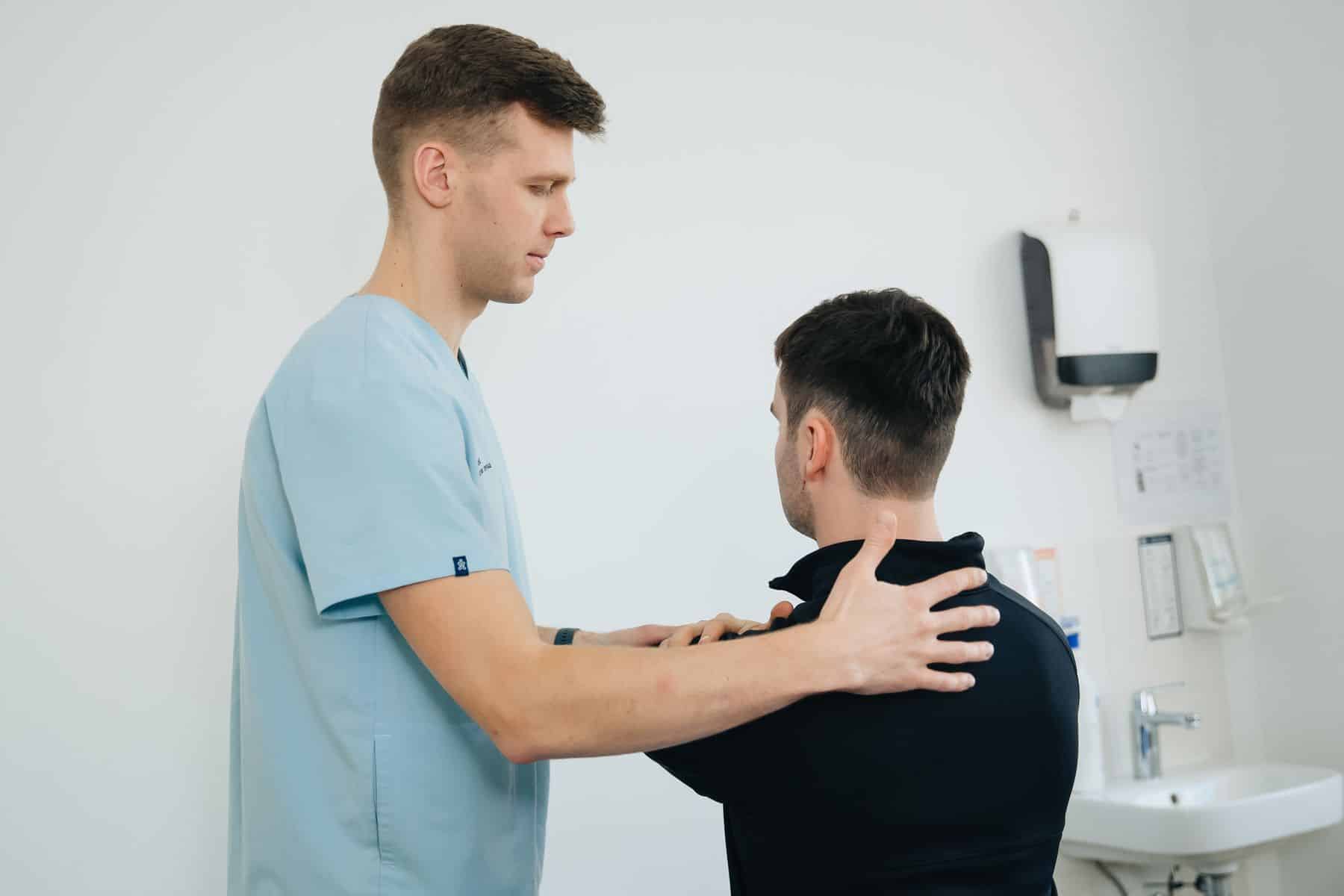 Fysioterapeut undersøger skulder og øvre ryg hos en patient