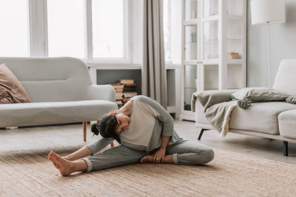 Kvinde laver rolig bevægelse derhjemme som led i håndtering af fibromyalgi og arvelig sårbarhed