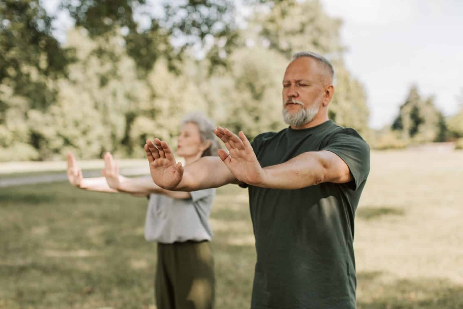 Ældre par dyrker tai chi udendørs som skånsom bevægelse ved fibromyalgi