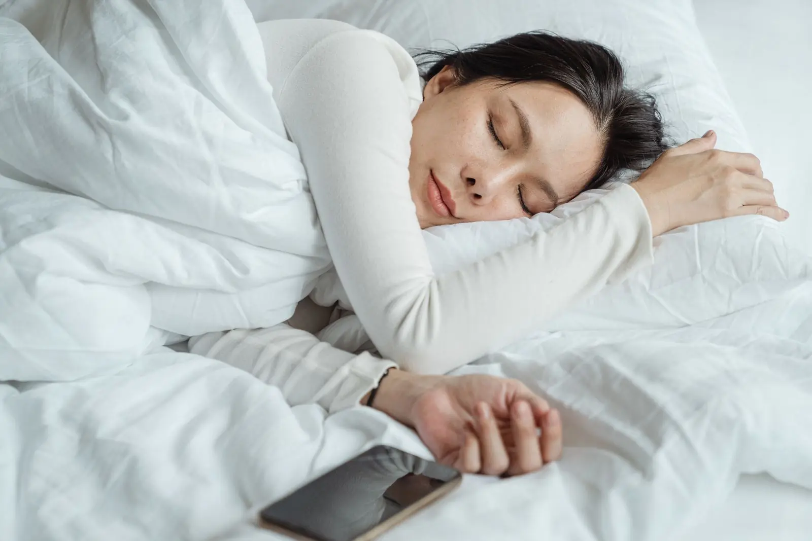 Kvinde sover på siden med støtte fra en pude
